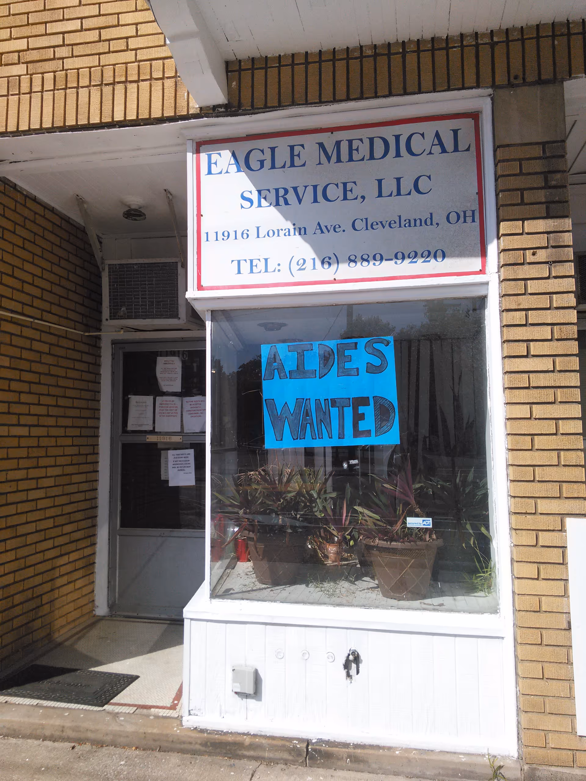 Exterior storefront of Eagle Medical Service, LLC with blue AIDES WANTED poster in the window.