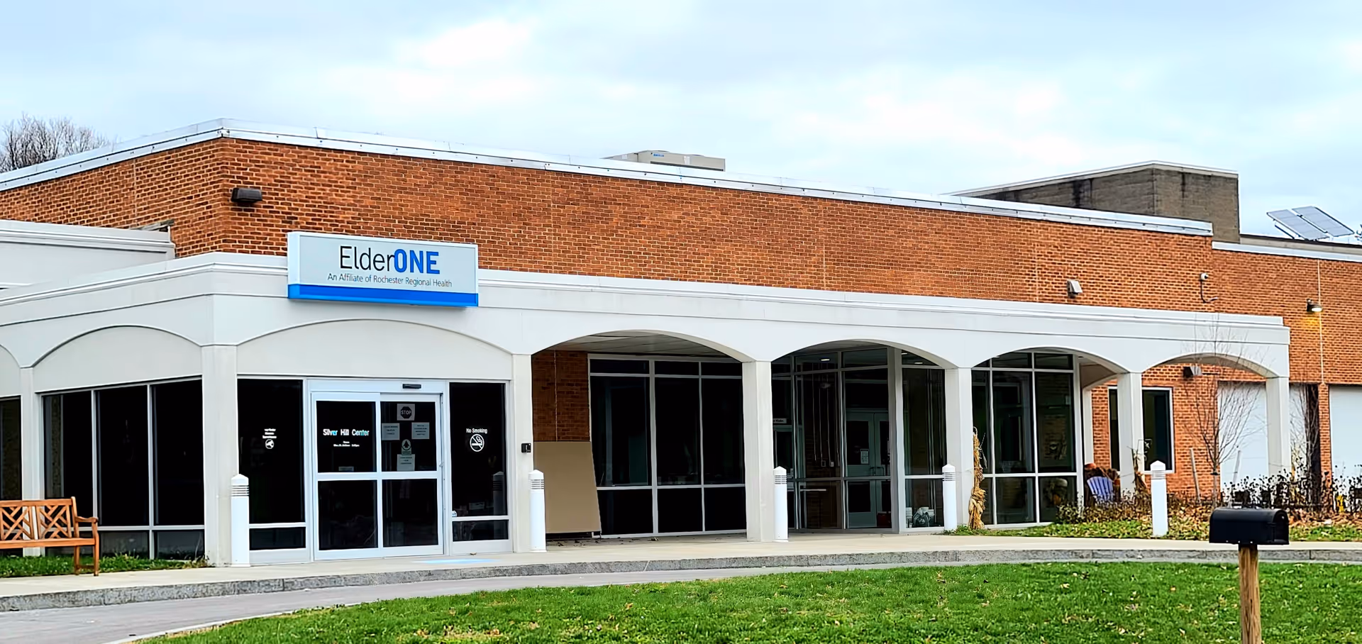 Exterior view of ElderONE North Park PACE Center with brick facade and arched entrance.