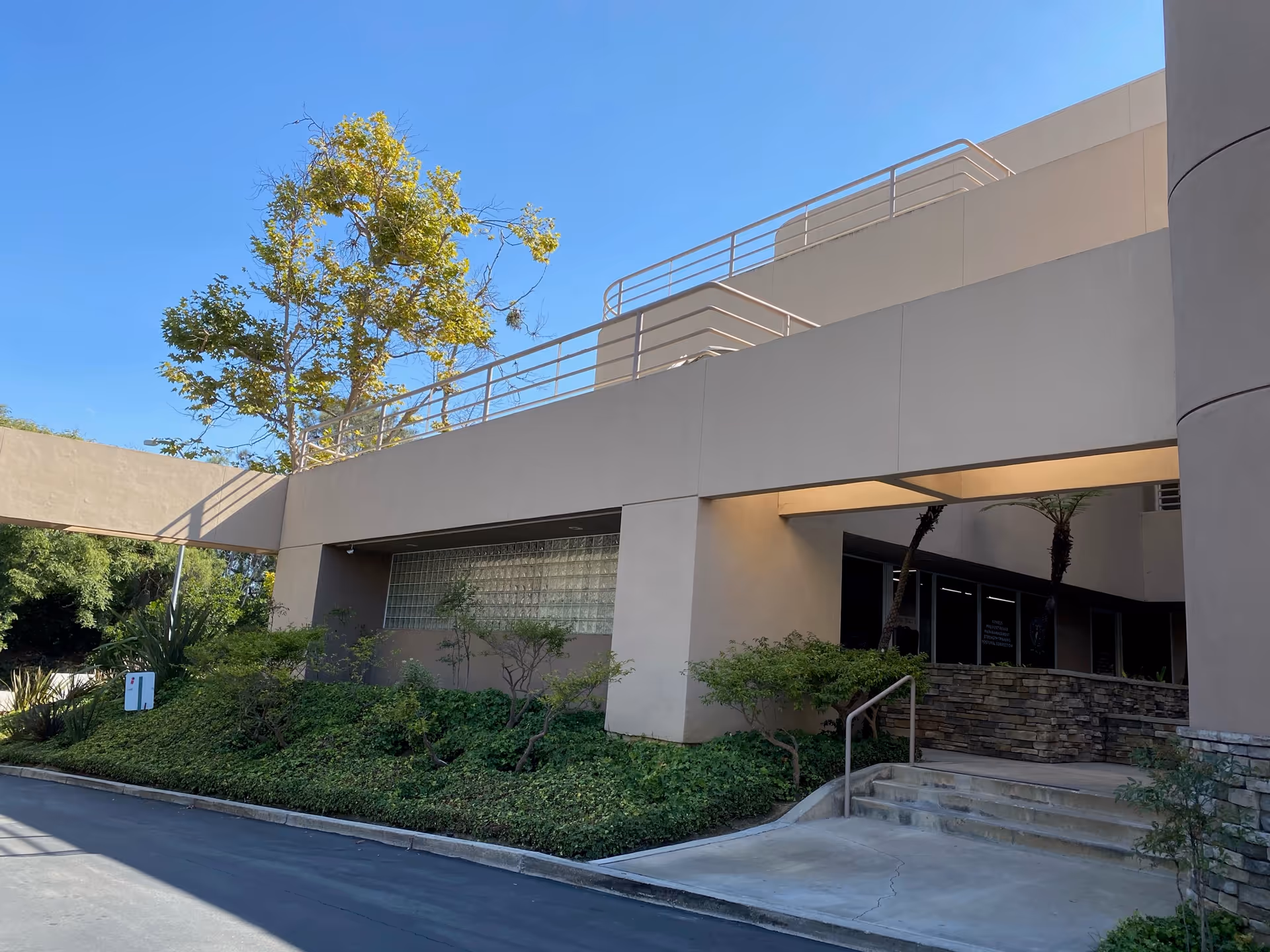 Modern exterior view of Aspire Home Healthcare facility with entry stairs and landscaping.