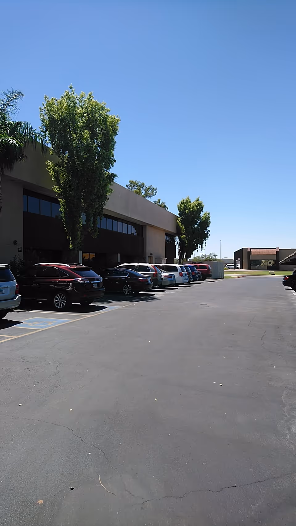 Exterior view of Care Givers of Arizona facility with a row of parked cars.