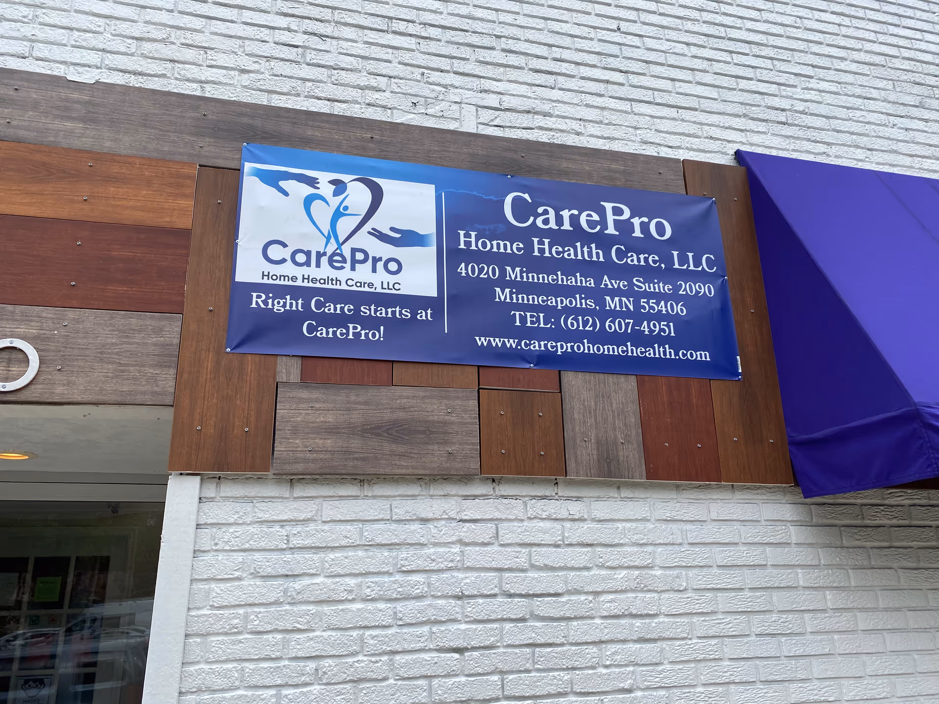 Blue CarePro banner on brick building exterior advertising home health care services.