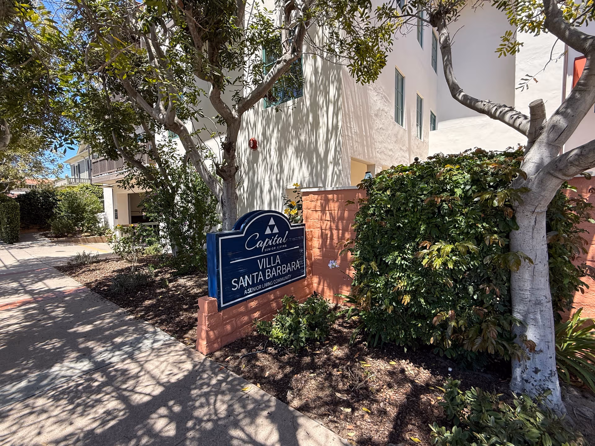 Exterior view of Villa Santa Barbara entrance with sign and landscaping
