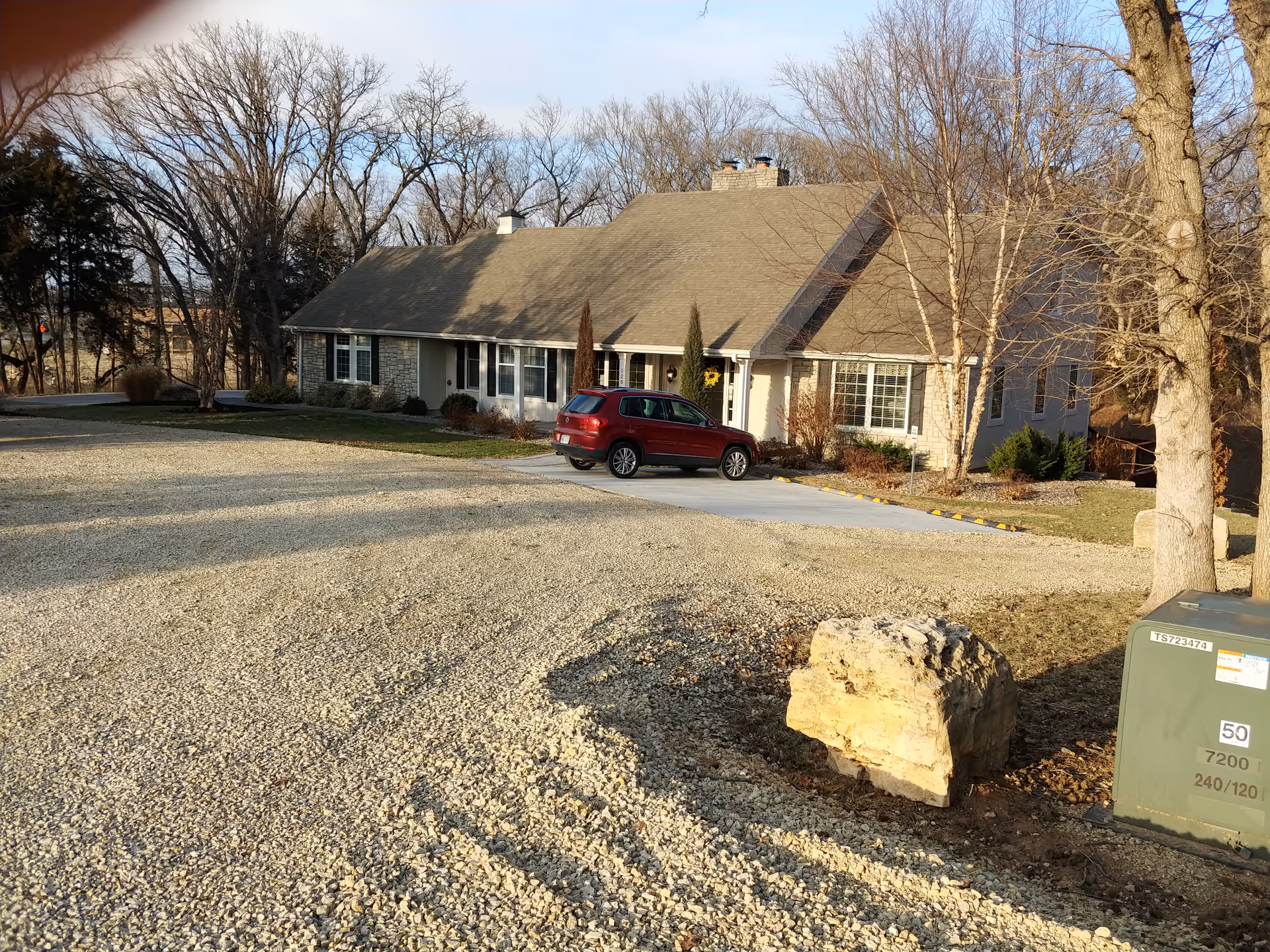Front view of Meadowlark Hills Retirement Community with a gravel lot and red SUV.