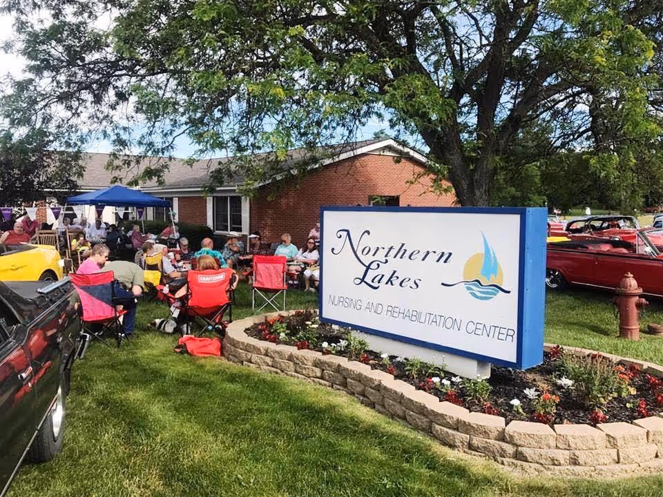Outdoor gathering at Northern Lakes Nursing and Rehabilitation Center with residents seated in lawn chairs.