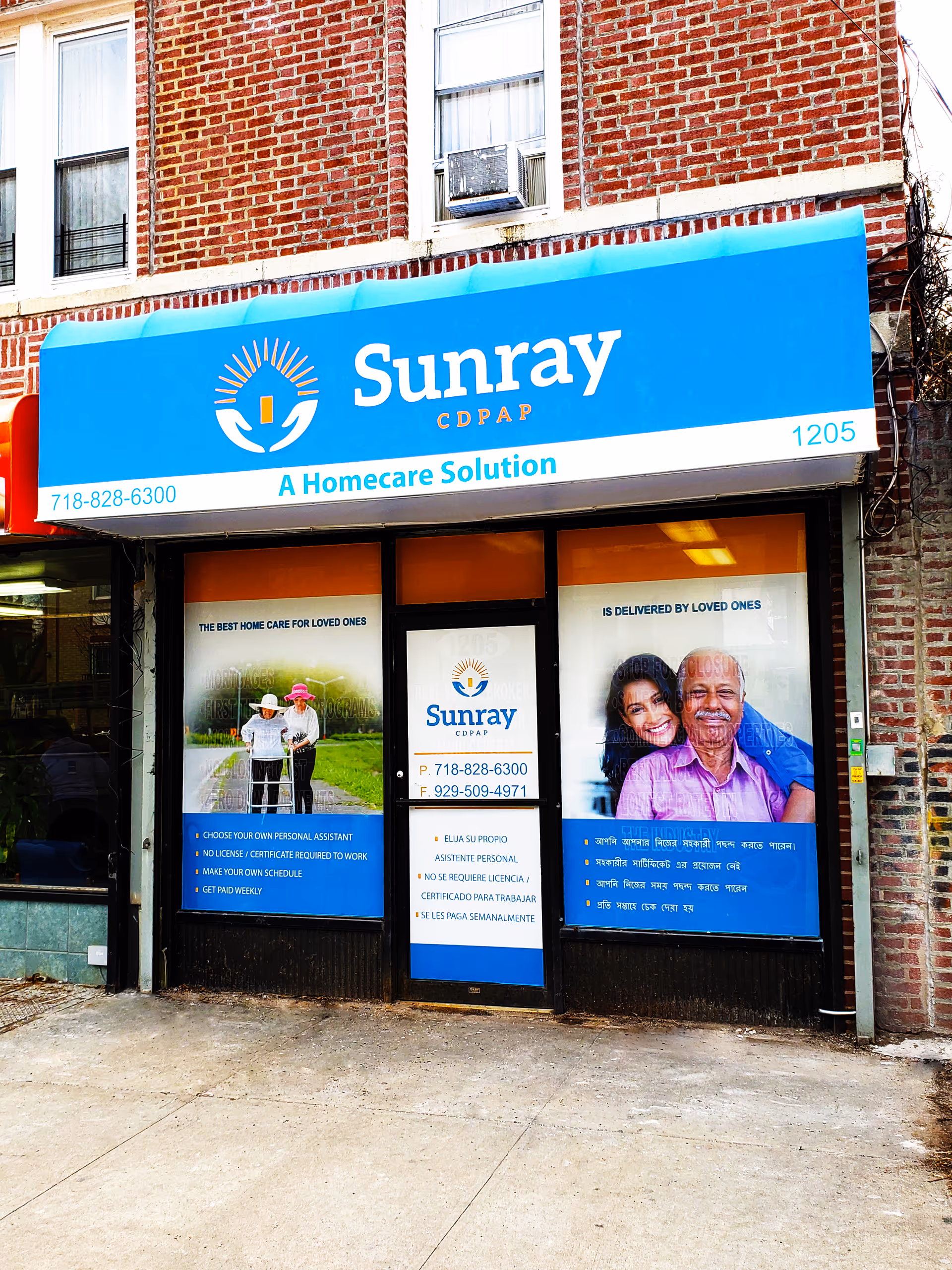 Blue Sunray Home Care storefront sign on brick building with window posters.