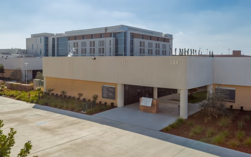 Exterior view of a modern senior living facility with a covered entrance and landscaping.