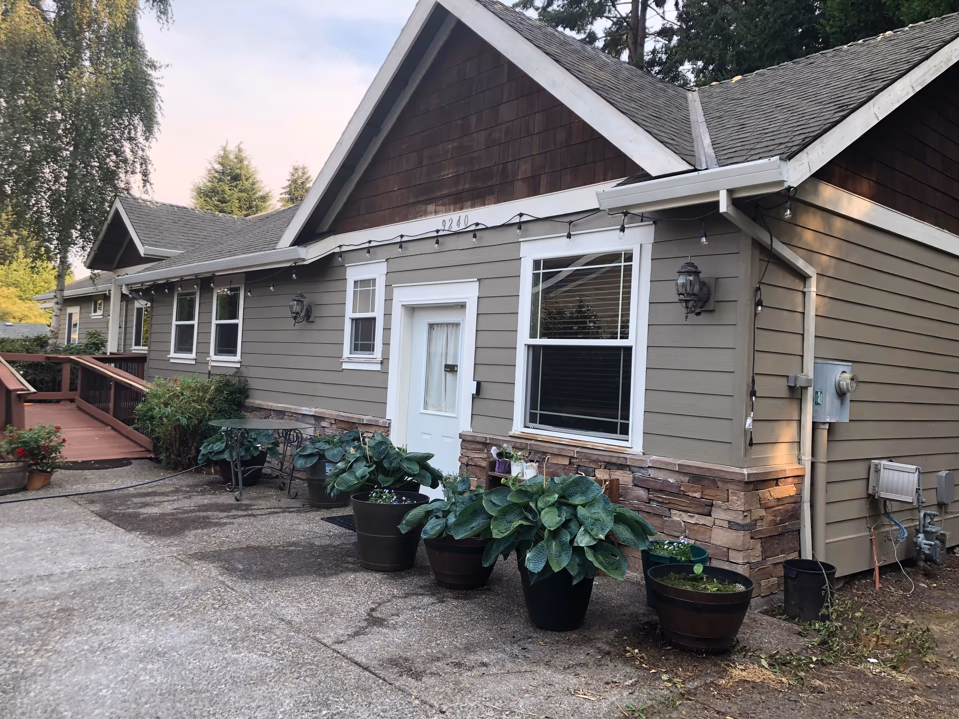 Exterior of Applewood Adult Care Home: a single-story house with gray siding and plants.