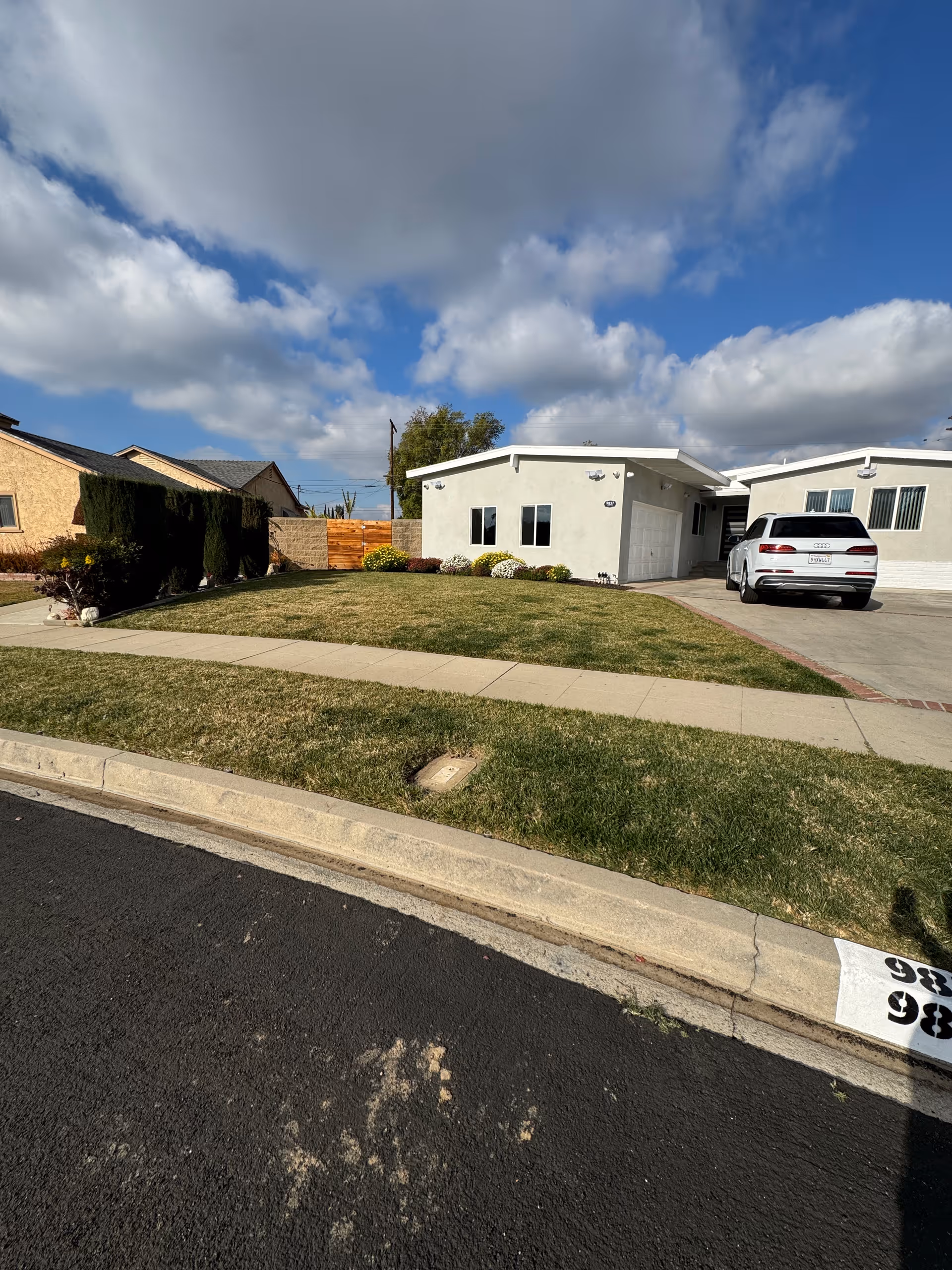 Front exterior of a single-story residential care facility with a driveway and parked car.