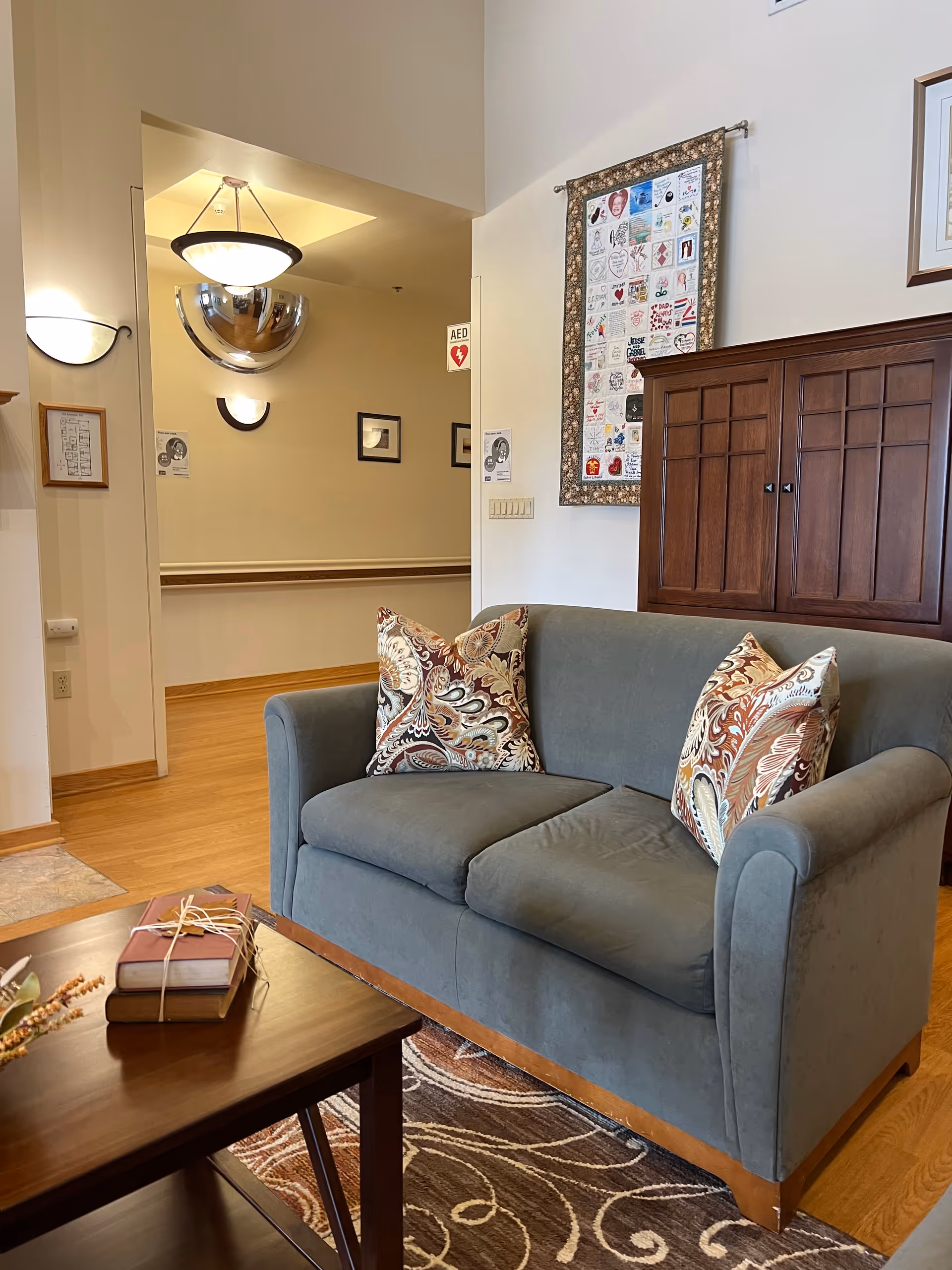 Blue sofa with decorative pillows in a bright senior living common area.