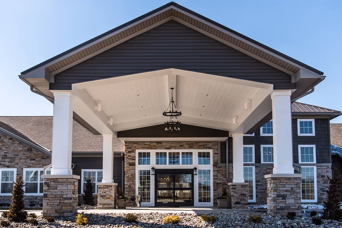 Exterior view of Charter Senior Living of Hopkinsville entrance with pillars and stone facade.