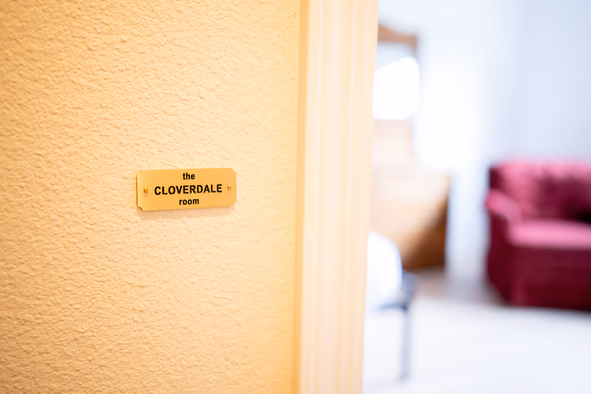 Close-up of a wall plaque reading the CLOVERDALE room in an interior.
