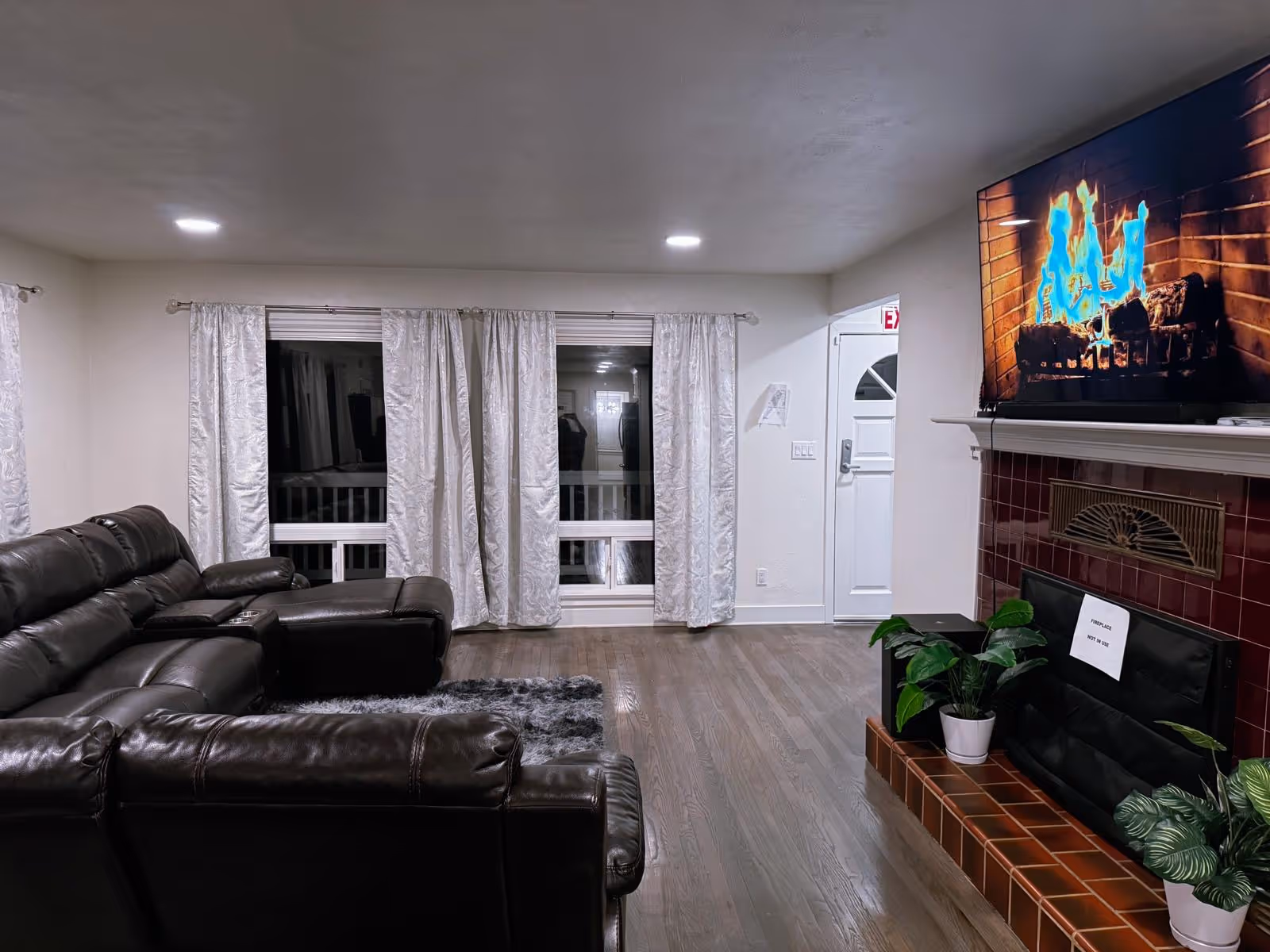 Cozy living room with a leather sectional, fireplace, and mounted TV.