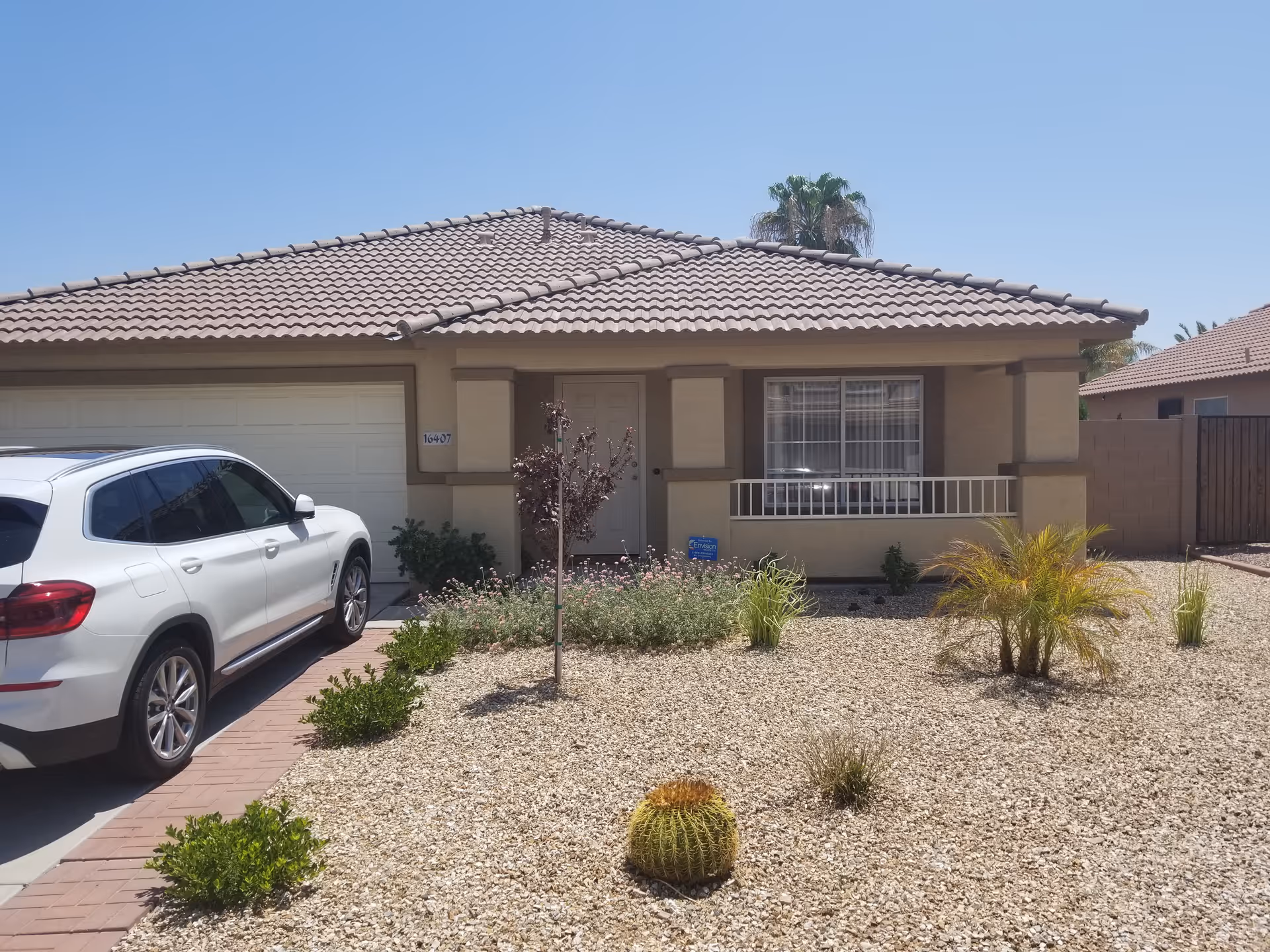 Single-story beige senior living facility with tiled roof and a white car parked in the driveway.