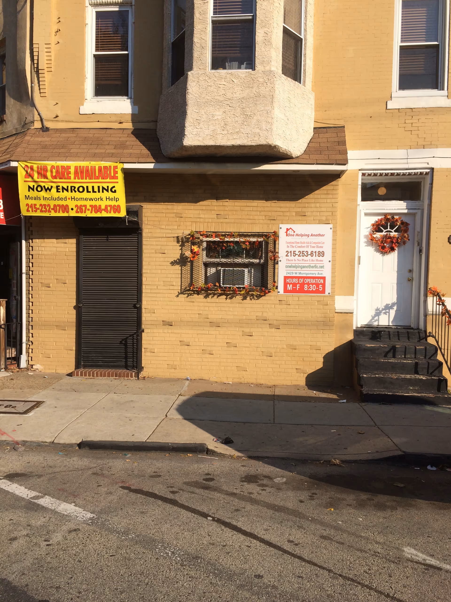 Exterior view of a yellow brick building with signs for One Helping Another Home Health Services