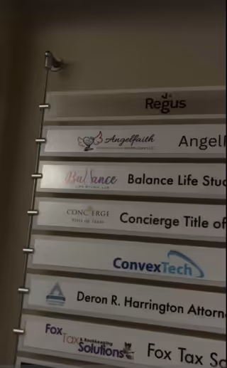 Interior wall with stacked signboards listing multiple business names.