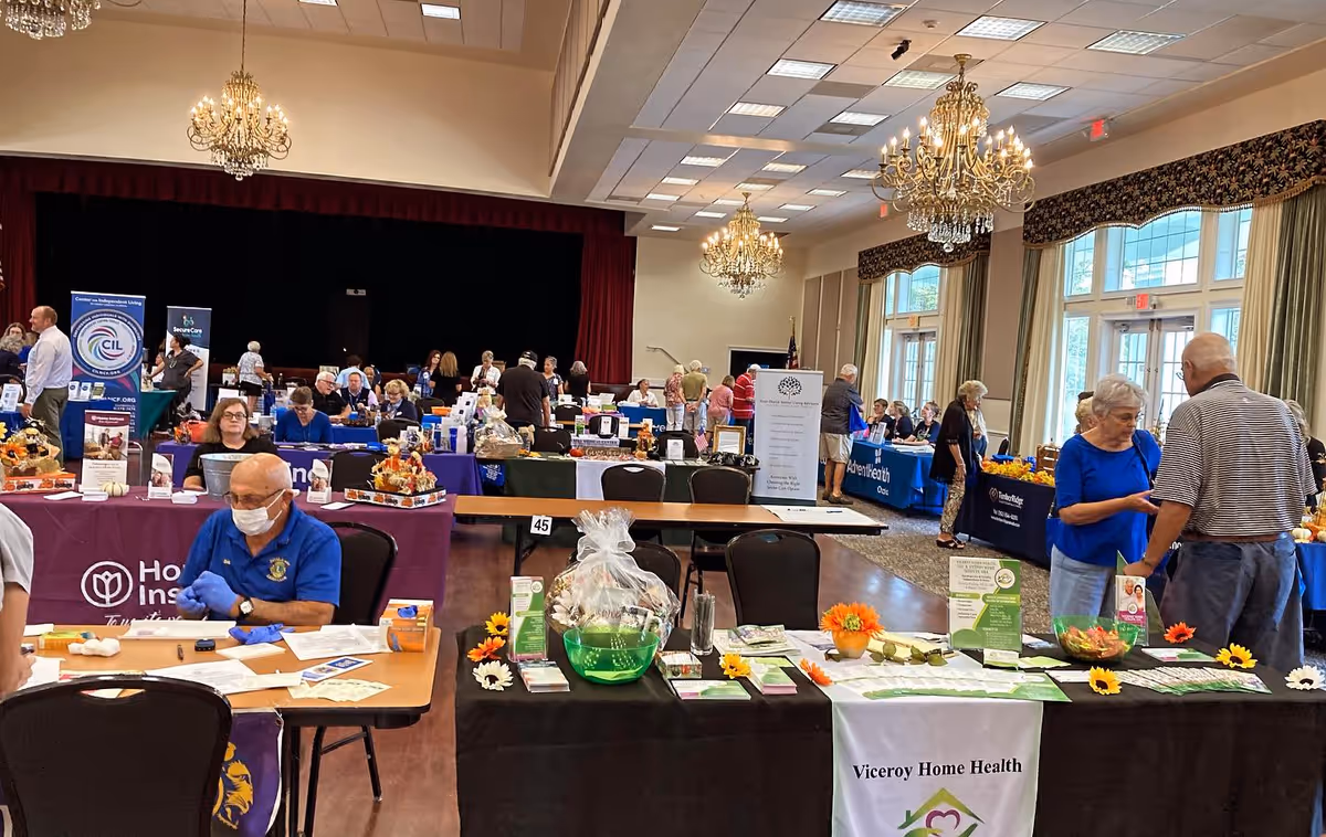 Indoor hall filled with booths and attendees at a health fair featuring Viceroy Home Health.