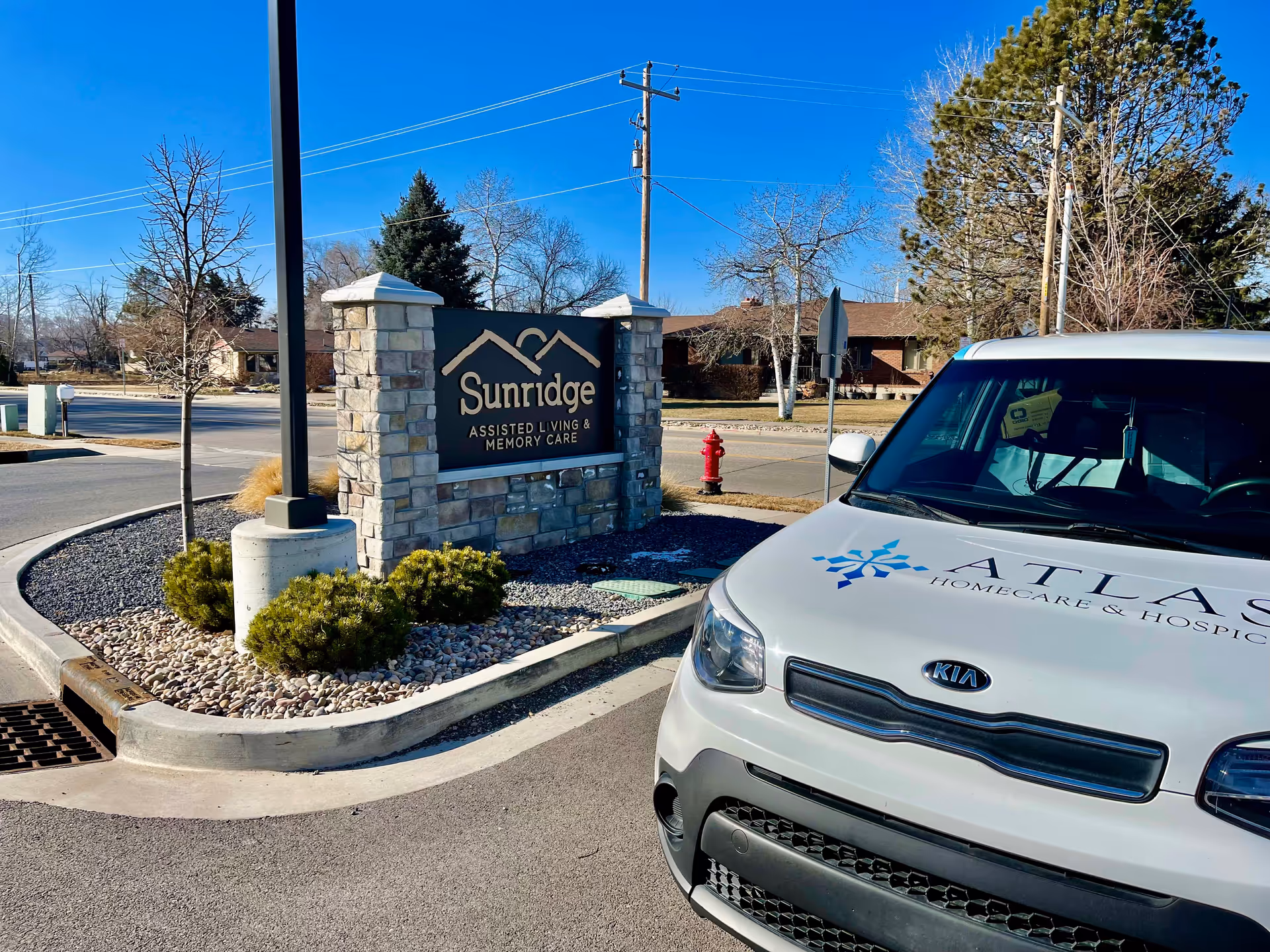 Sunridge Assisted Living sign with an Atlas Homecare van parked nearby.