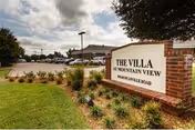 Exterior view of The Villa at Mountain View with their sign and landscaped entry.