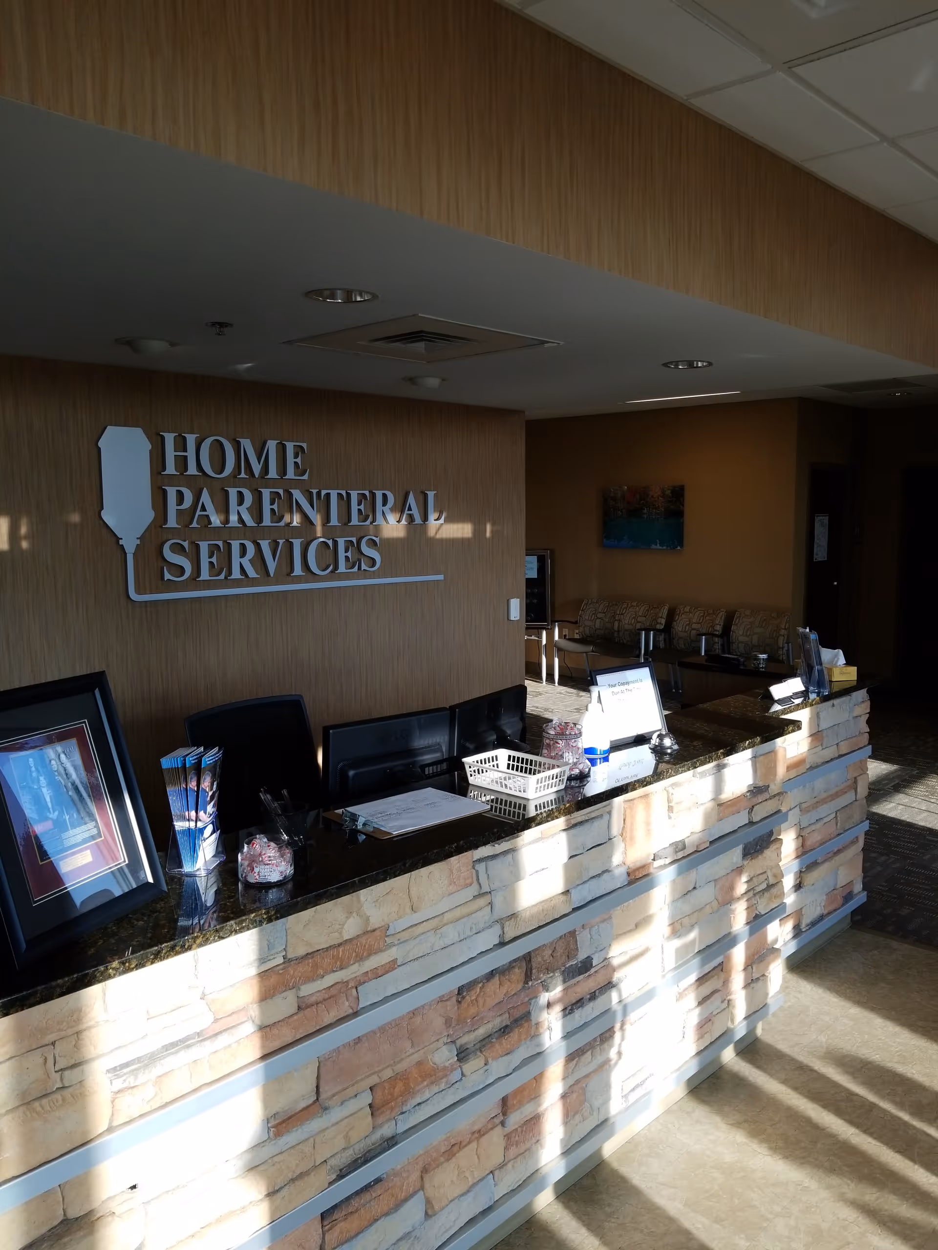 Reception desk in a lobby with a stone front and seating area.