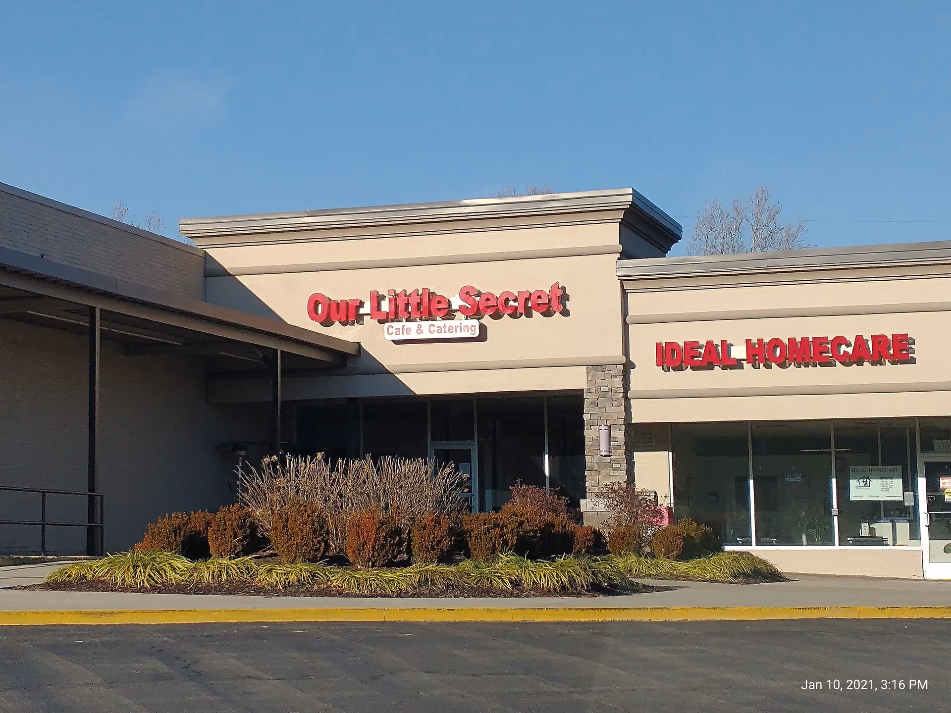 Exterior view of a strip mall with Ideal Homecare and Our Little Secret storefronts.