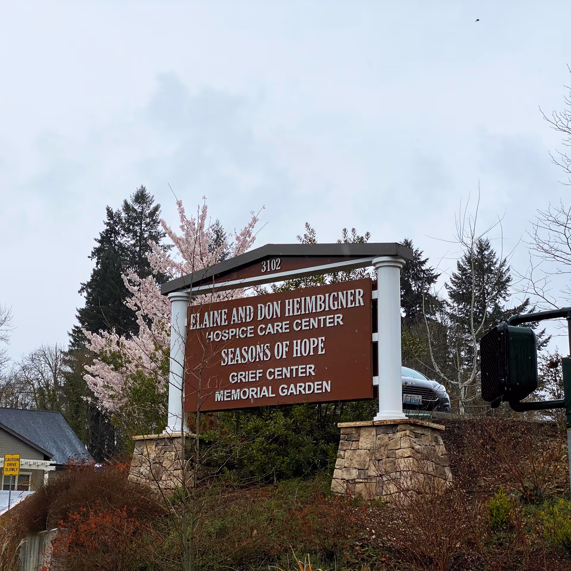 Outdoor scene featuring a large sign for Elaine and Don Heimberger Hospice Care Center.