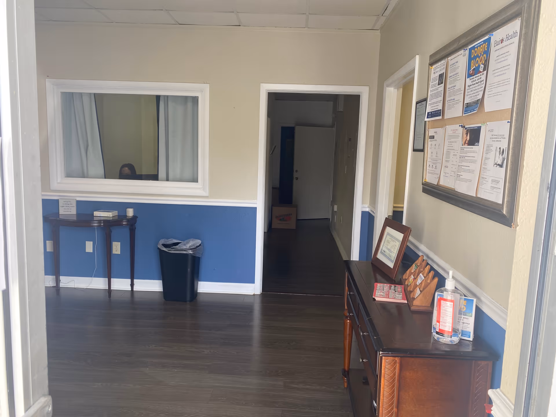 Interior hallway in a senior living facility with bulletin board and doorway