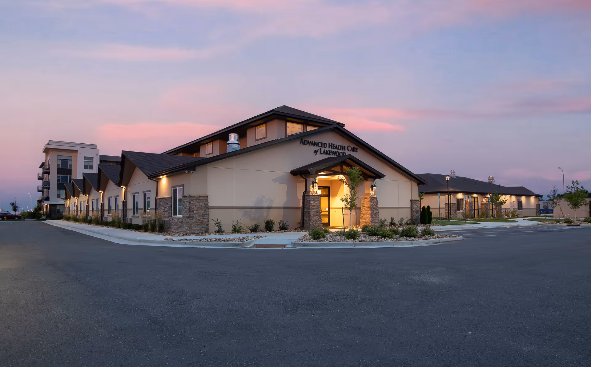 Exterior view of Advanced Health Care of Lakewood at dusk with entrance and parking lot.