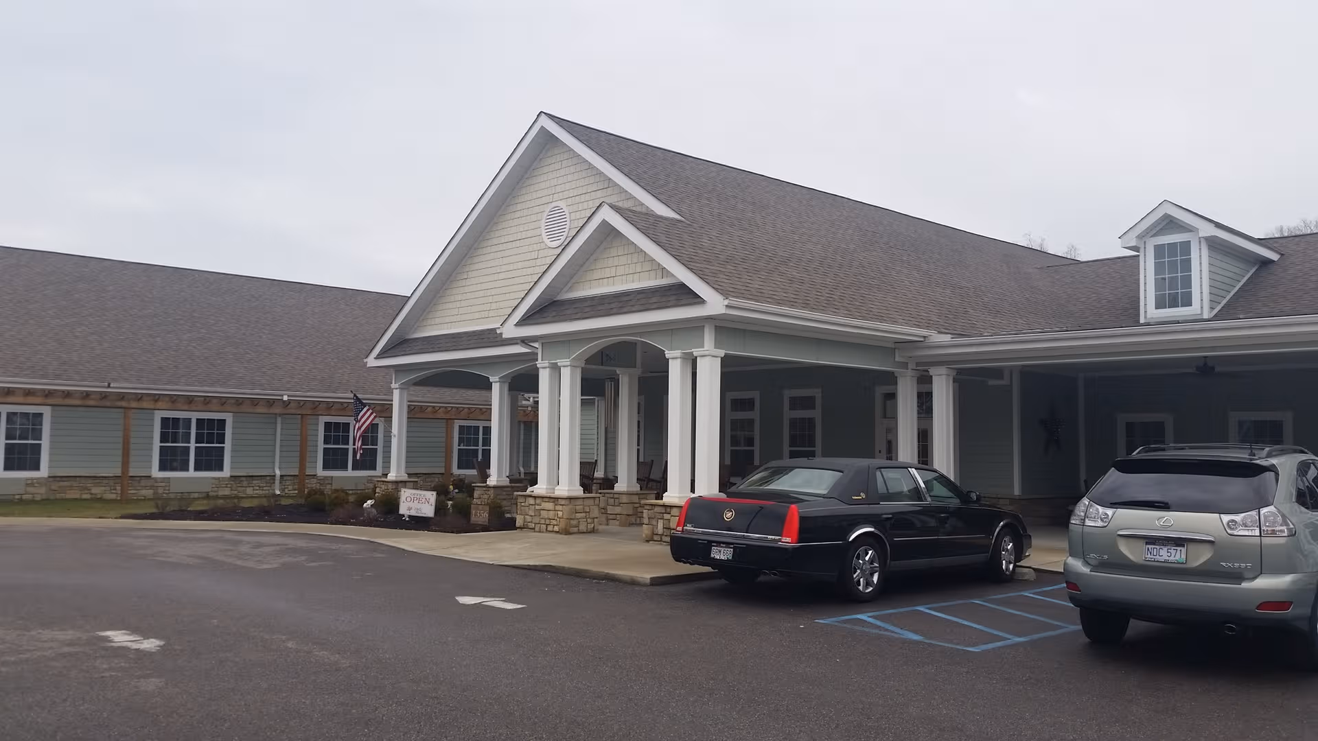 Front view of The Village at Riverview senior living facility with a covered entrance and cars