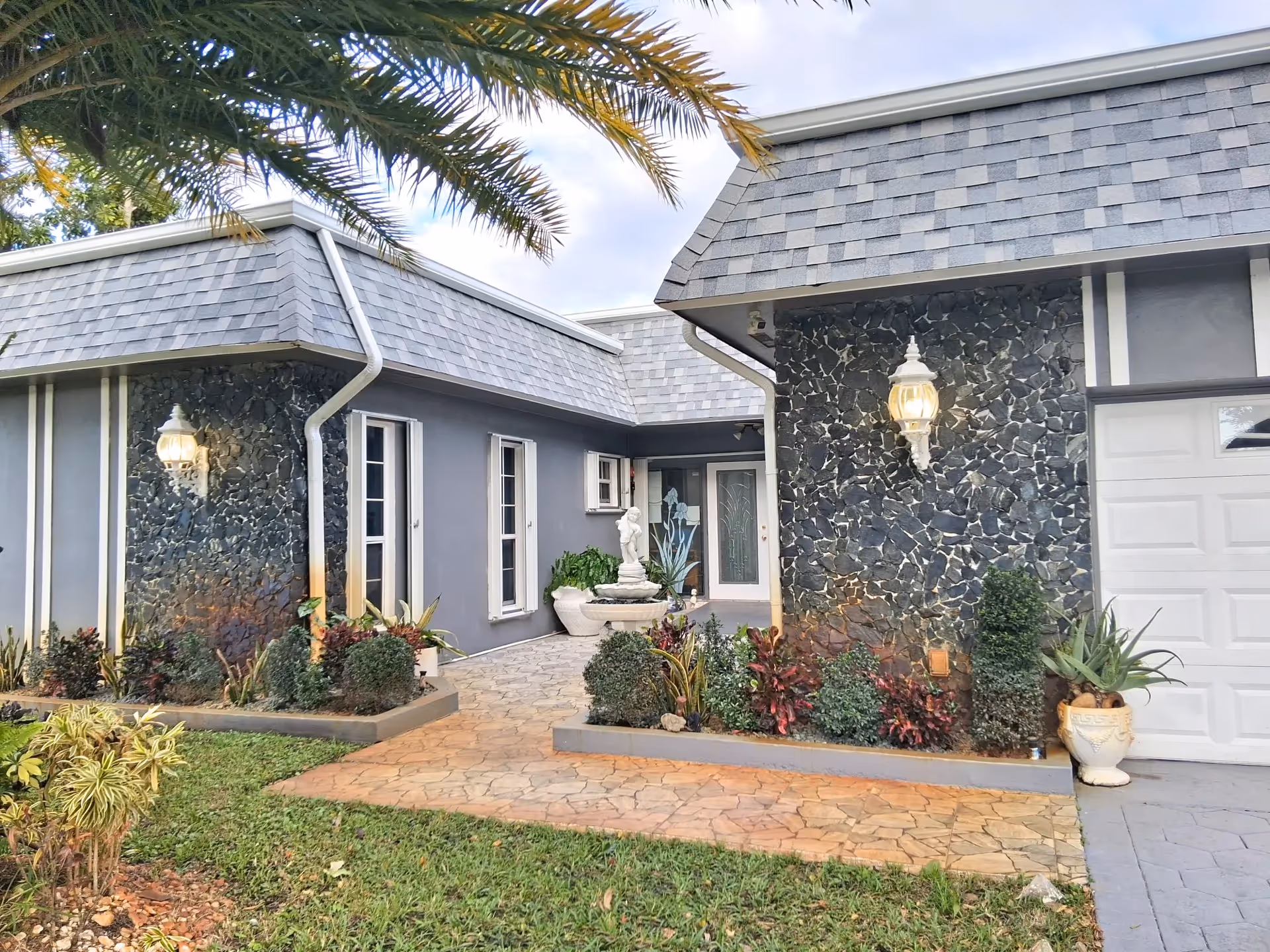 Modern stone facade exterior of a senior living facility with a front entrance and landscaping.