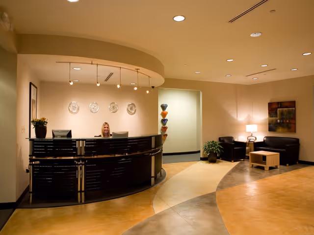 Reception desk in Home Care Freedom lobby with receptionist and seating area.