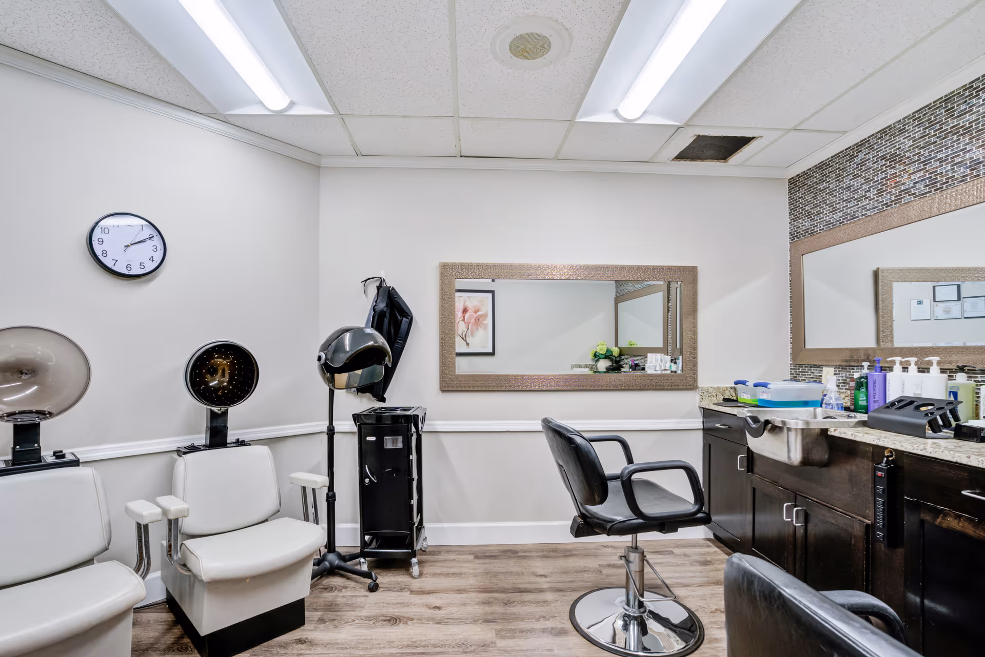 A hair salon in a senior care facility with chairs, mirrors, and styling station.
