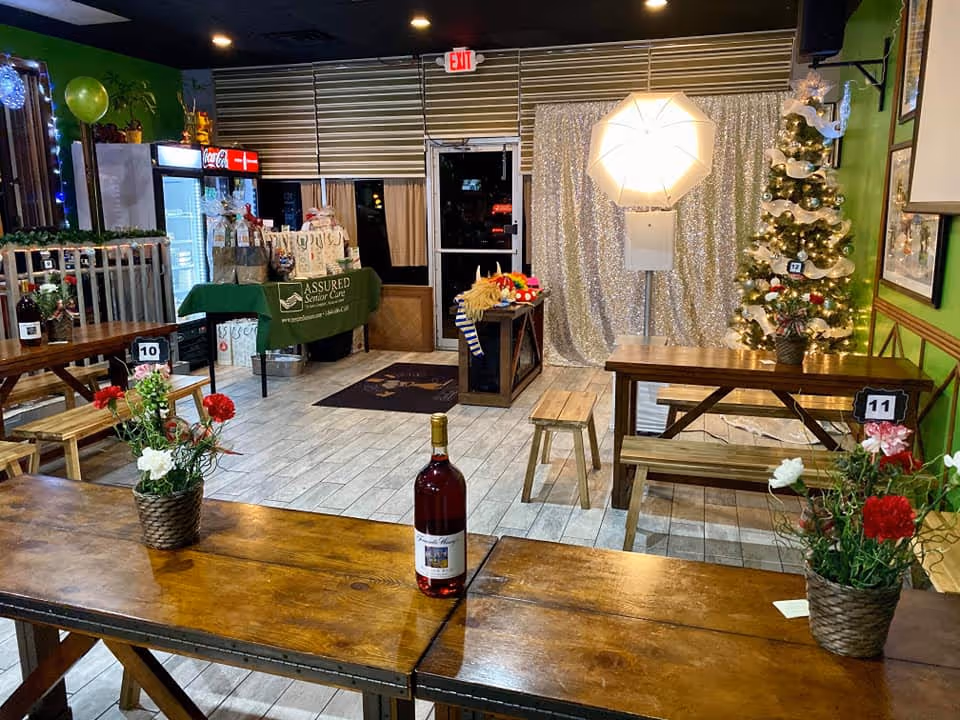 Indoor senior living dining space with wooden tables, benches, flowers, and Christmas decorations.