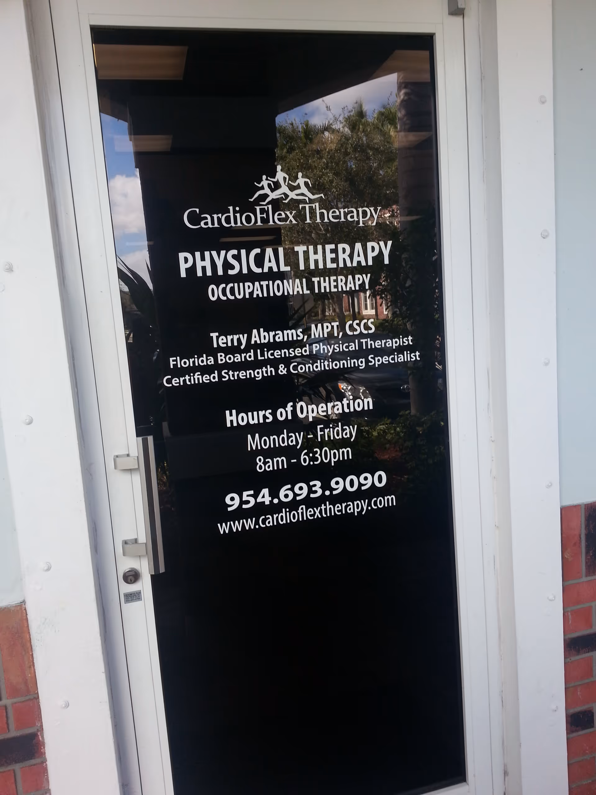 Exterior glass door displaying CardioFlex Therapy, physical therapy business sign and hours.