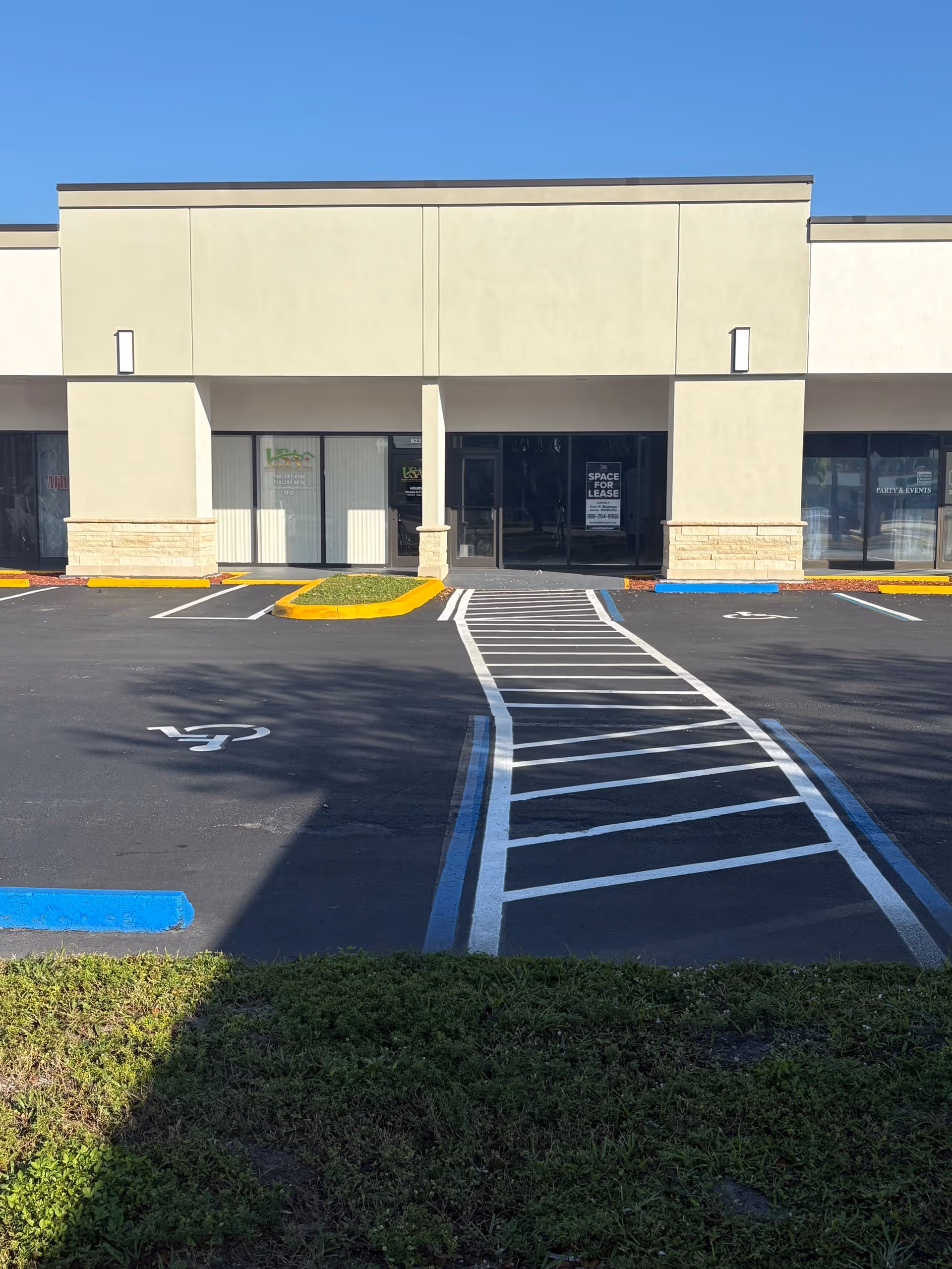 Front view of a beige senior living facility with parking and a handicapped space.