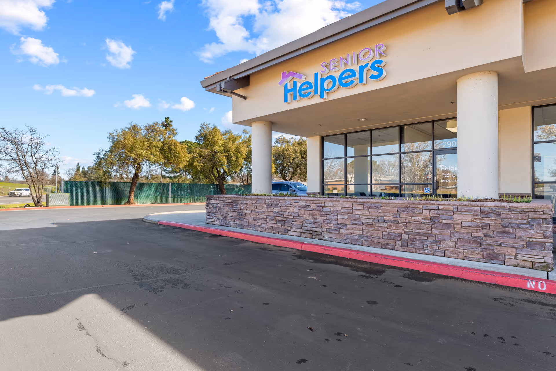 Exterior view of a Senior Helpers facility with front entrance and parking