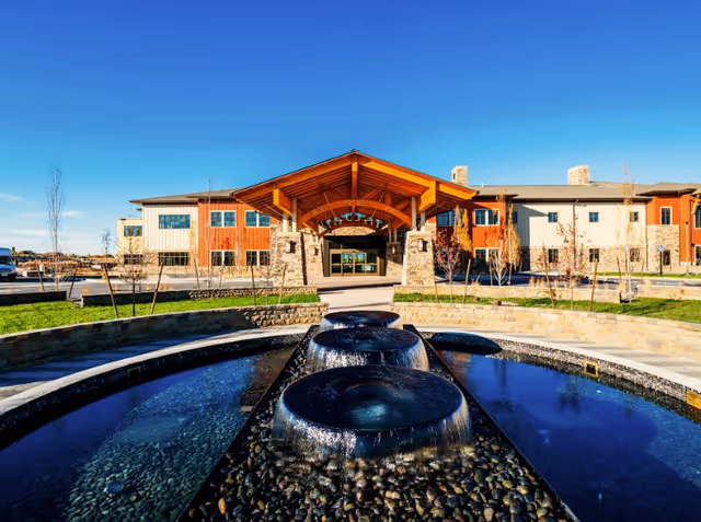 The Summit Vista building exterior features a central entrance and a water fountain.