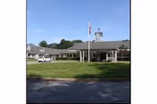 Exterior view of Elderwood at Burlington with flag, lawn, and entrance