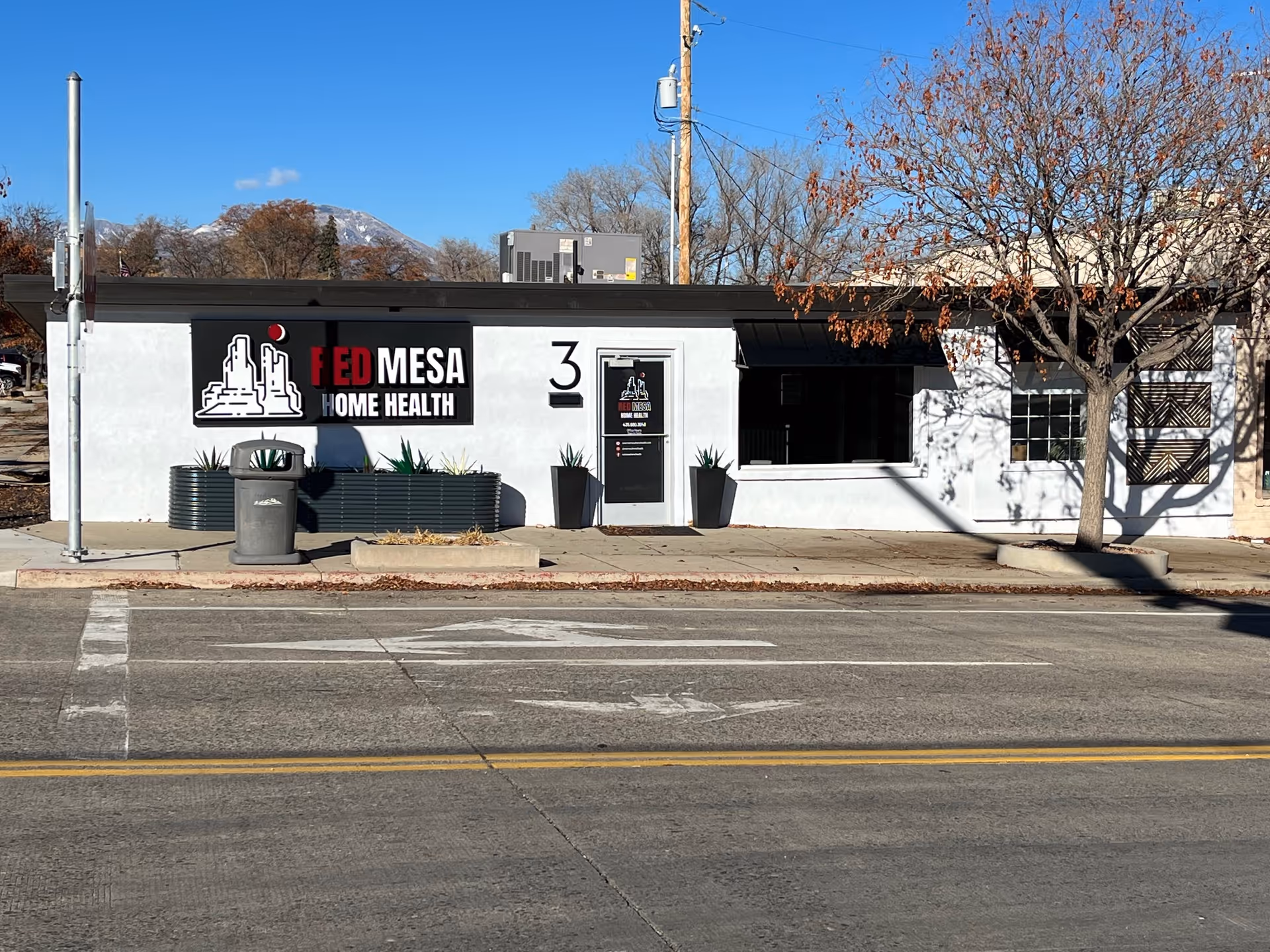 Exterior view of Red Mesa Home Health building with signage and planters.