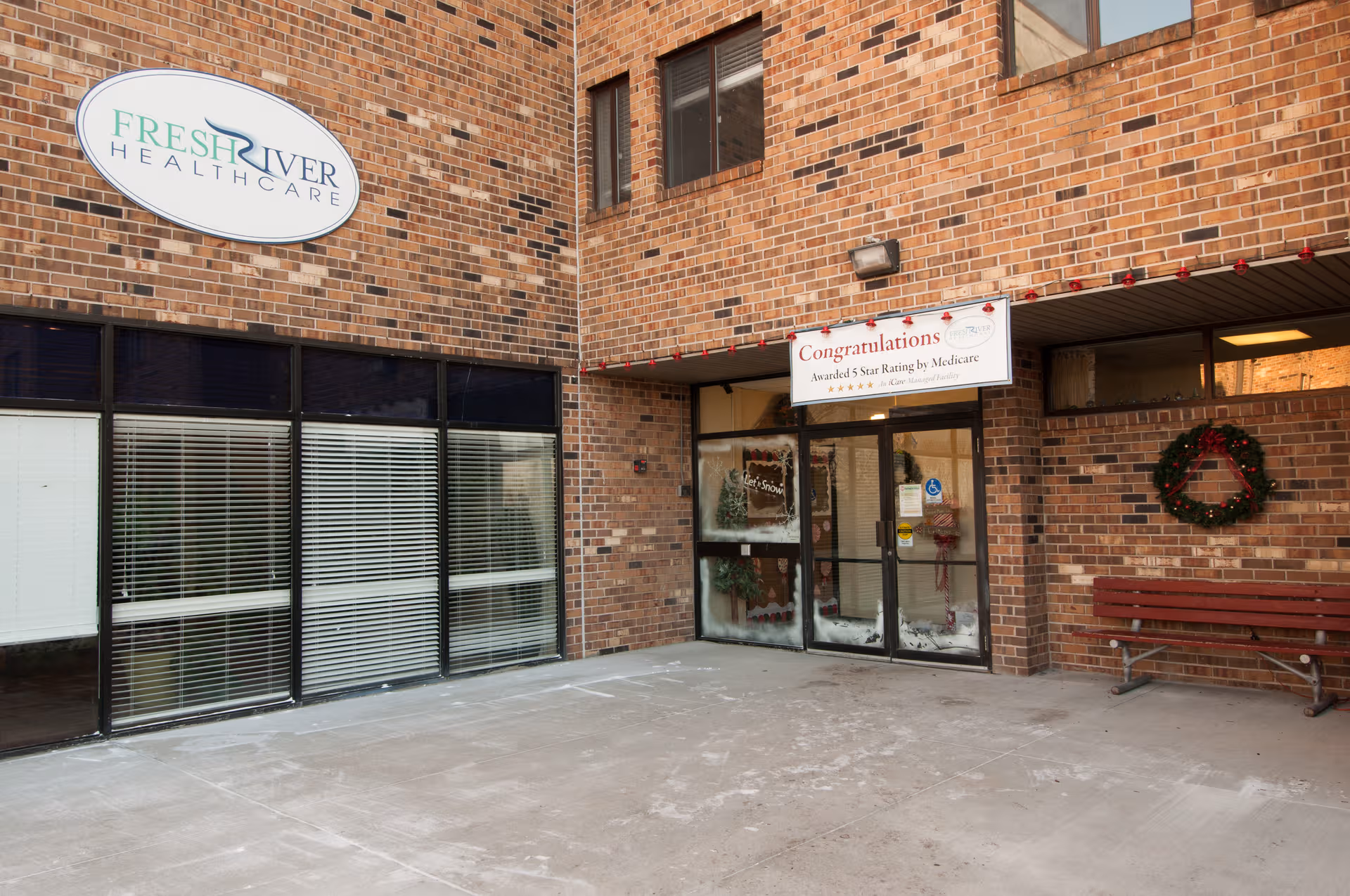 Brick exterior of Fresh River Healthcare with glass entrance and wreath