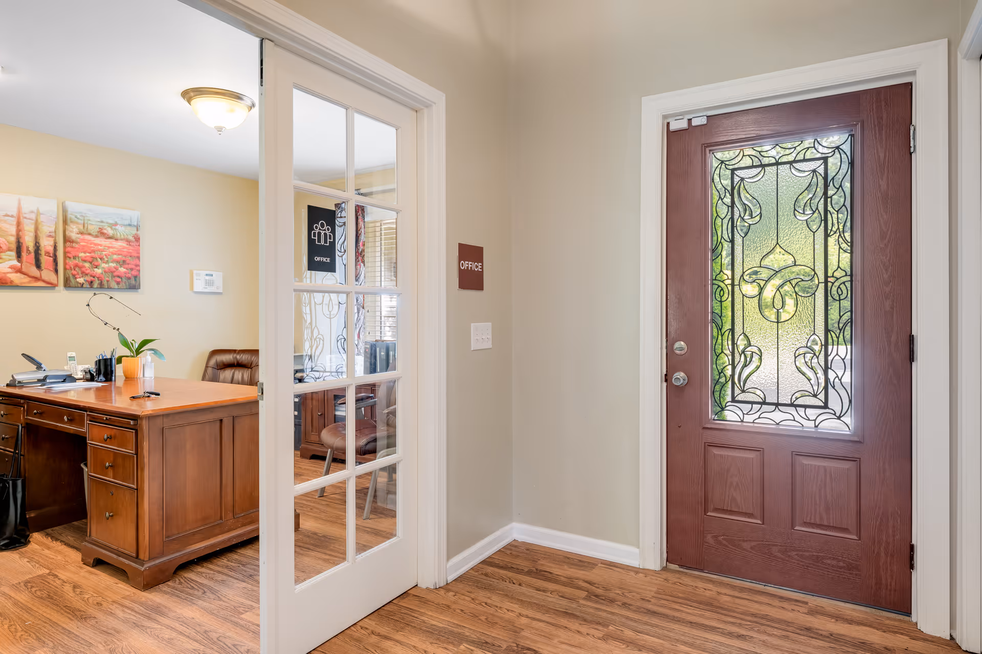 Entrance hallway shows a glass-paneled office door beside a red stained-glass front door.