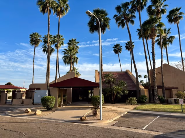 Exterior view of Shiv Adult Care Home with palm trees and a covered entrance.