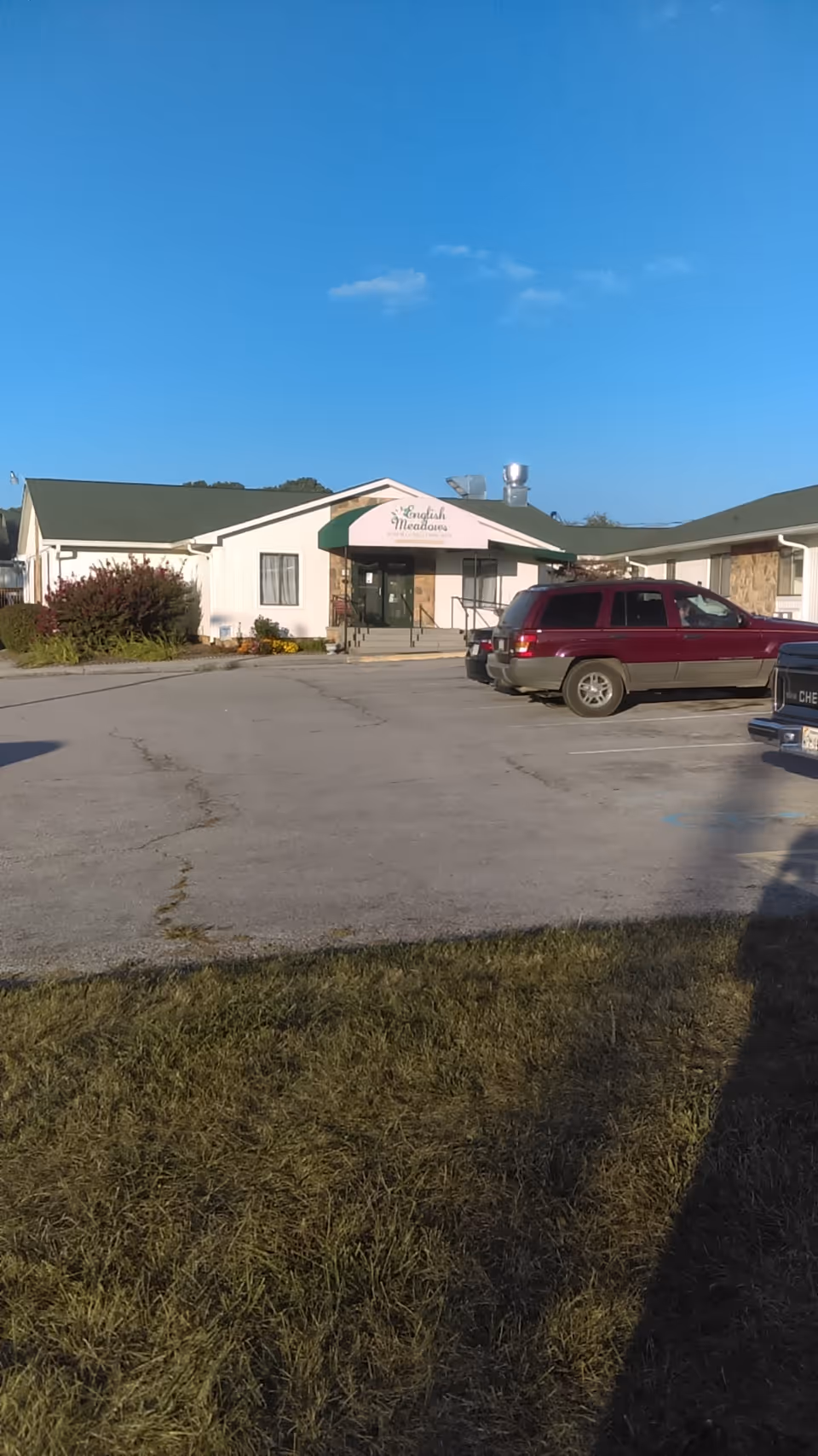 Exterior view of Spring Oak at Christiansburg with a front entrance and parked cars