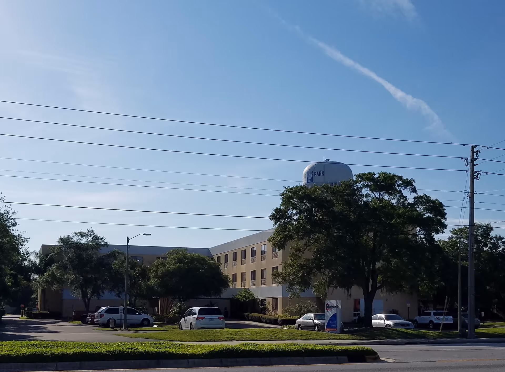 Exterior view of Pinellas Park Post-Acute and Rehabilitation Center with cars and trees.