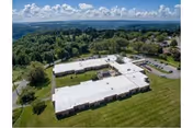 Aerial view of Alpine Rehabilitation & Nursing Center exterior with white roof and surrounding green grounds.