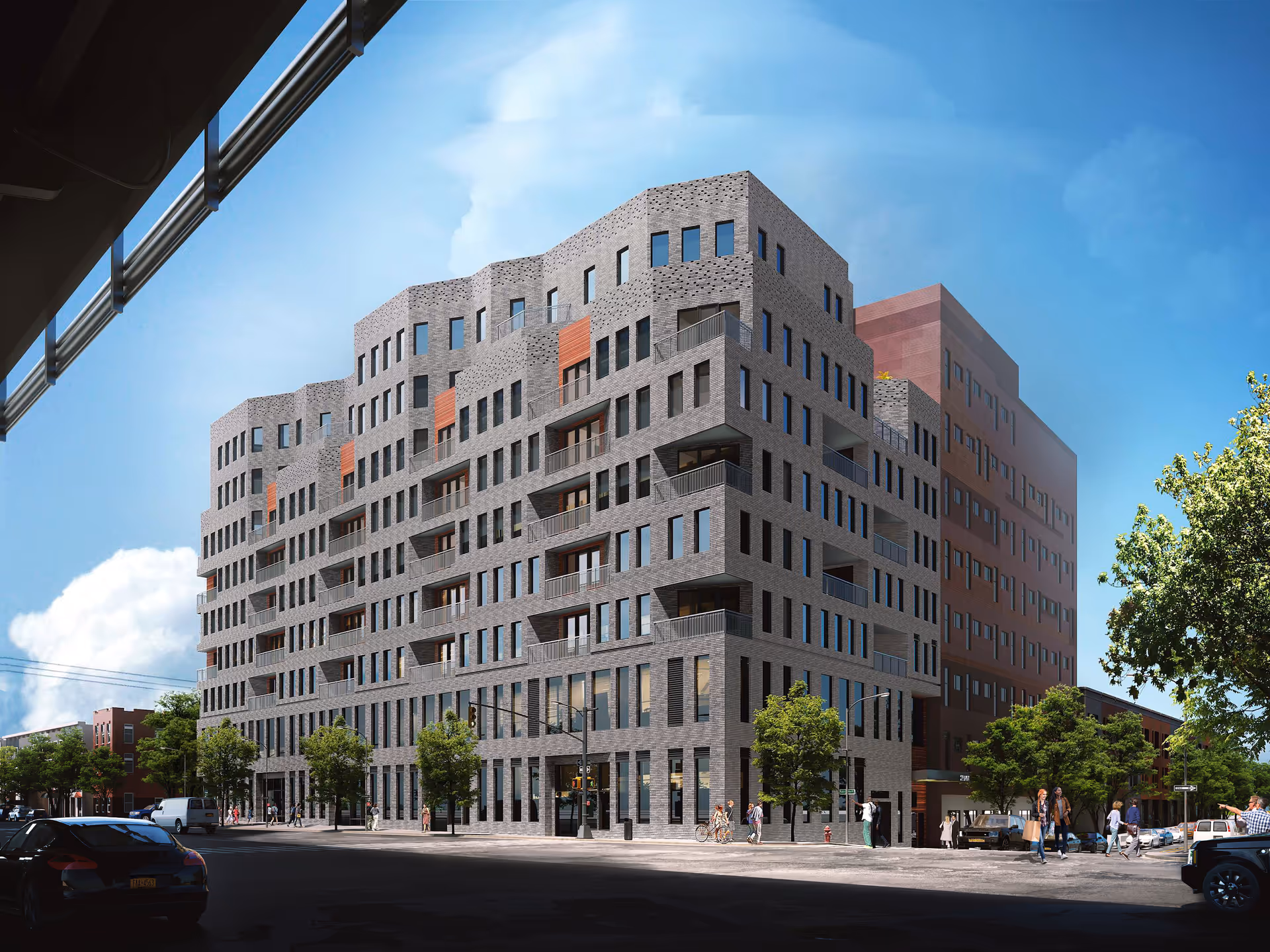 Modern multi-story brick building with numerous windows along a city street.