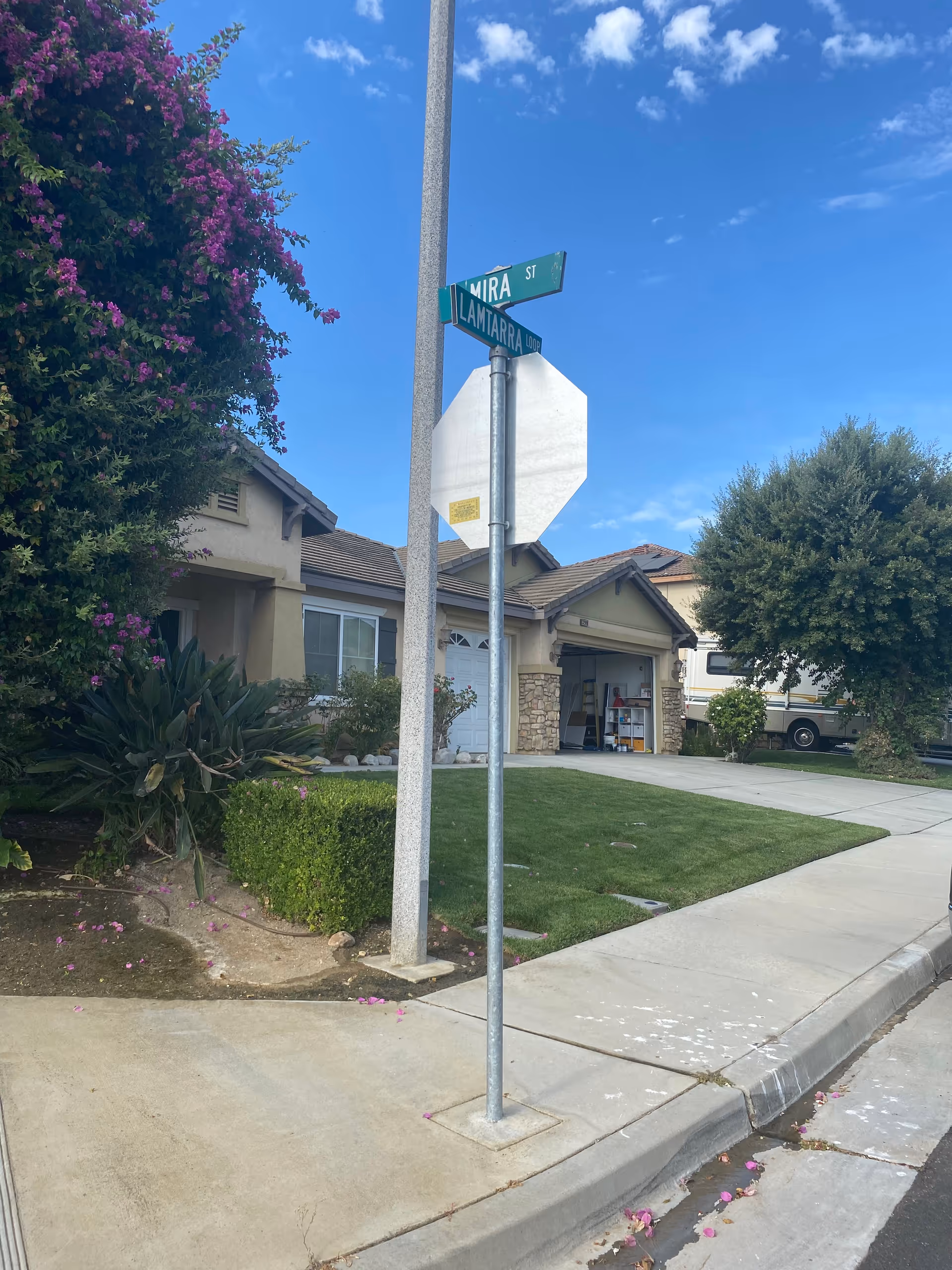 Sunset Lamtarra Loop exterior of a residential facility with lawn, sidewalk, and street sign.
