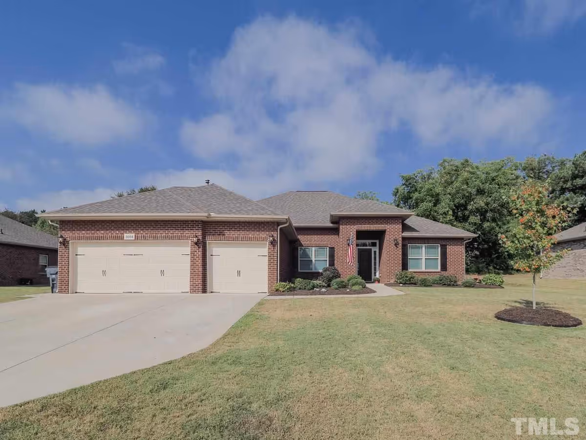Brick, single-story building with a two-car garage and a manicured front lawn.