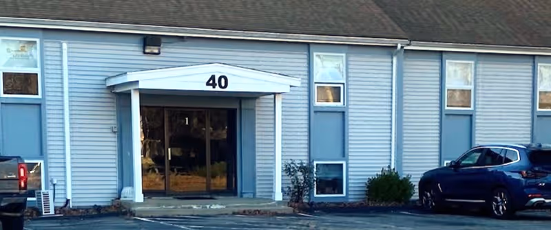 Blue senior living facility exterior with glass entrance and the number 40 above doors.