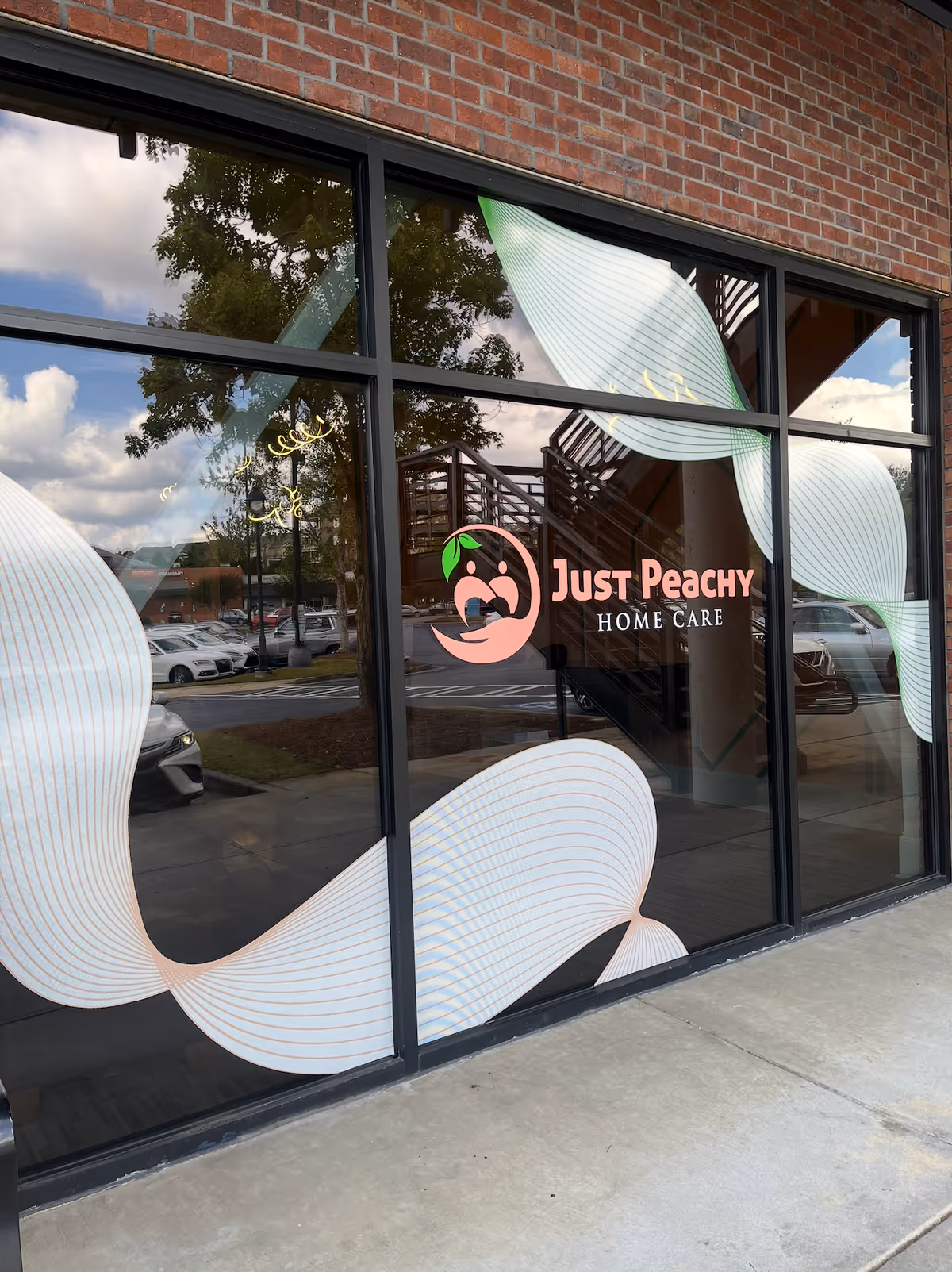 Storefront window displays Just Peachy Home Care logo on brick exterior.