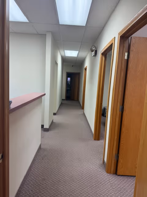 Narrow hallway inside a senior care facility with doors along the corridor.